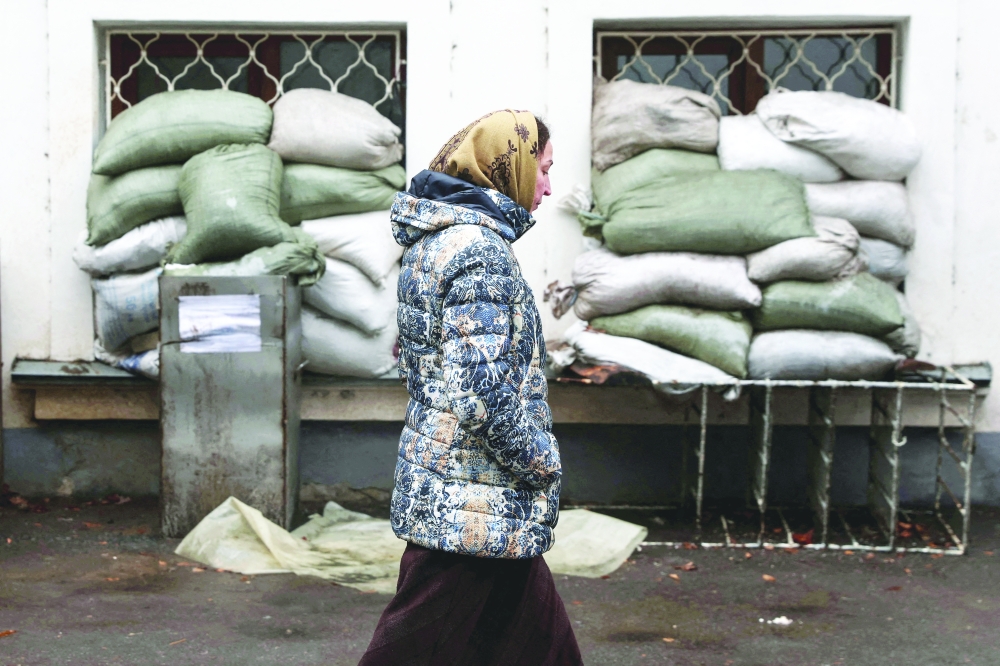A woman who sought refuge at the Sviatohirsk Cave Monastery, as Russia’s attack on Ukraine continues, walks by sand bags, in Sviatohirsk, Ukraine, on Friday. — Reuters