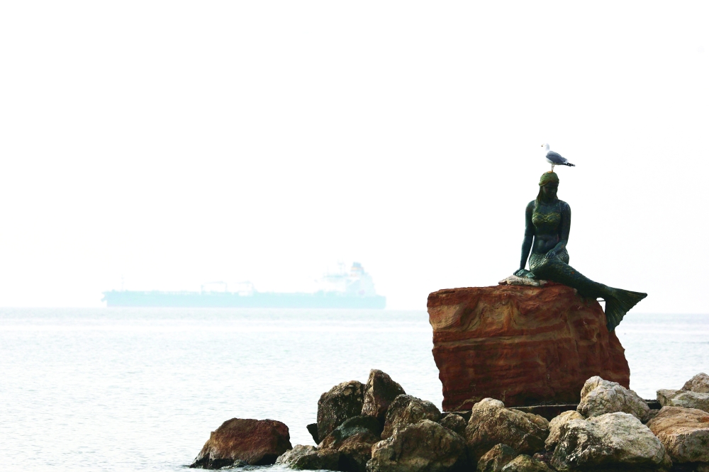 A seagull sits on top of a mermaid statue, with the crude oil tanker Humble Warrior carrying Kazakh oil is in the background at the Dardanelles Anchorage off Sarkoy, near Tekirdag, Turkey, on Friday. — Reuters