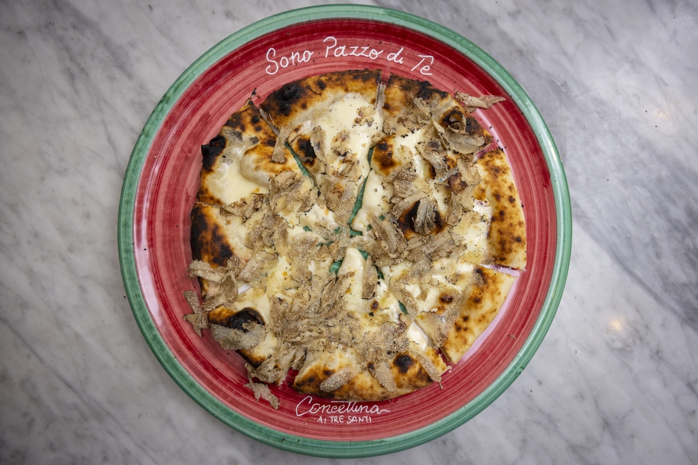 Pizza generously shaved with white truffle from Alba, in Piedmont, at Concettina ai Tre Santi in Naples, Italy, in October 2022. (Roberto Salomone/The New York Times)