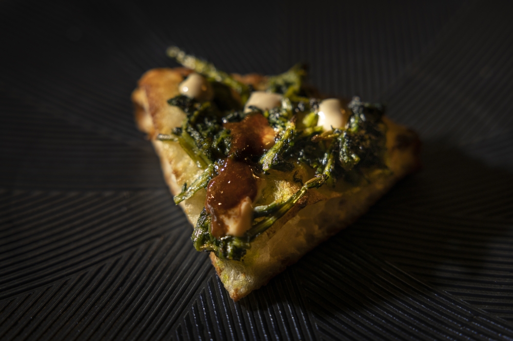 A tasting-menu slice at I Masanielli with three kinds of bitter: fermented sea urchin, fermented chicory and beer-infused ricotta, in Caserta, Italy, in October 2022. (Roberto Salomone/The New York Times)