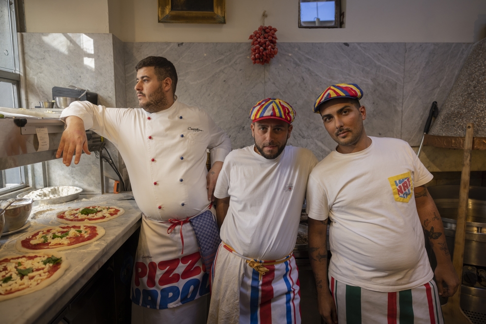 Members of the pizza-making team in the kitchen at Concettina ai Tre Santi in Naples, Italy, in October 2022. (Roberto Salomone/The New York Times)
