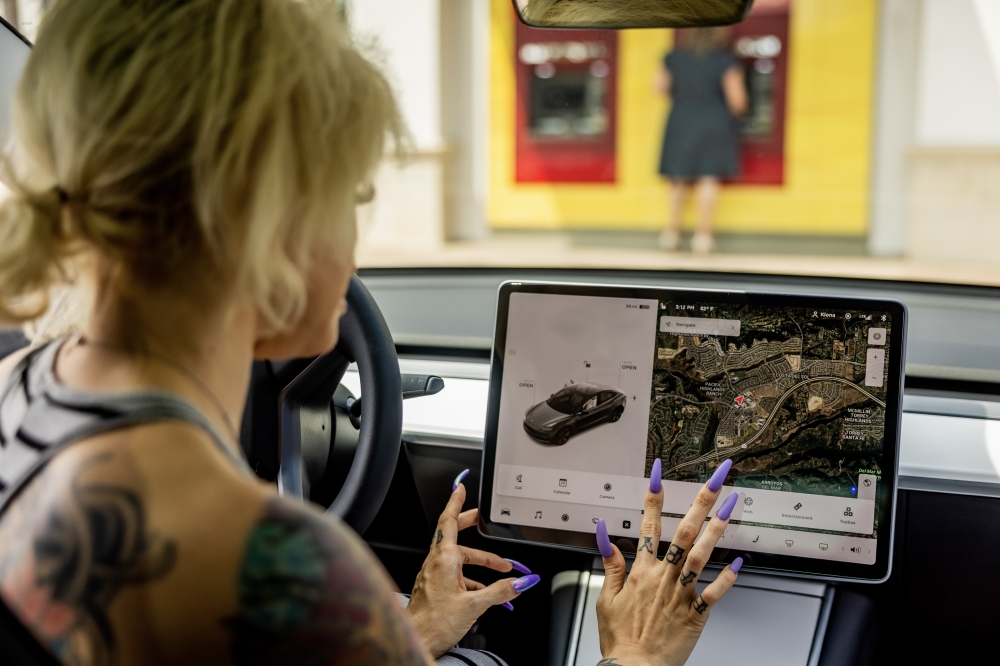 A woman looks at the display in a Tesla Model 3 car in San Diego, Calif., July 23, 2021. (Roger Kisby/The New York Times)