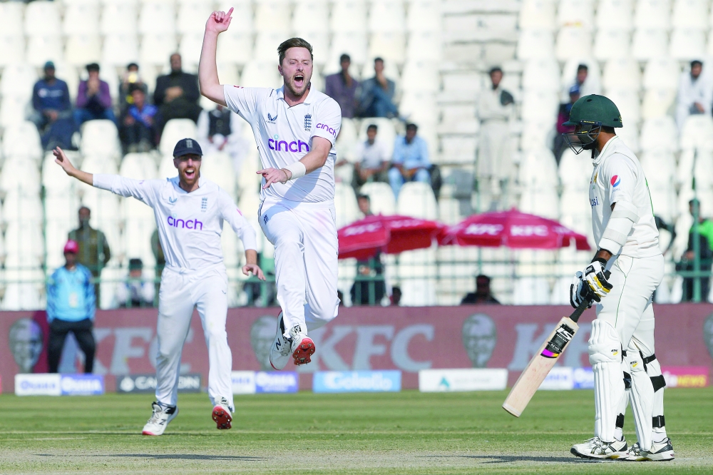 England's Ollie Robinson (C) celebrates after taking the last wicket of Pakistan's Mohammad Ali (R) during the fourth day of the second cricket Test match between Pakistan and England at the Multan Cricket Stadium in Multan on December 12, 2022.  (Photo by Aamir QURESHI / AFP)

