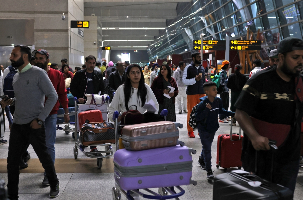 Travellers push carts with their luggage at the departure area of Terminal 3 at Indira Gandhi International Airport in New Delhi, India, December 14, 2022. 