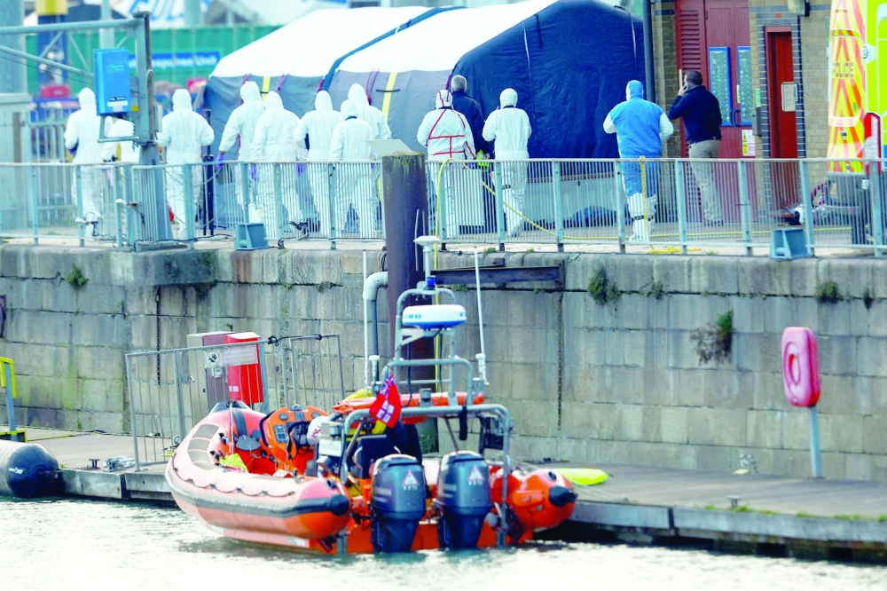 Police forensics officers arrive at the Port of Dover after a small boat loaded with migrants capsized in the English Channel, in Dover. -- Reuters