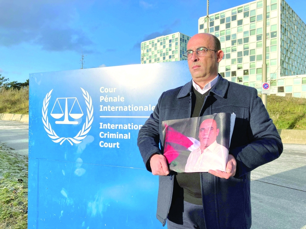 Ghassan Banat holds a picture of his late brother outside the International Criminal court (ICC) in the Hague, after submitting a case accusing top Palestinian officials over his death in custody. — AFP