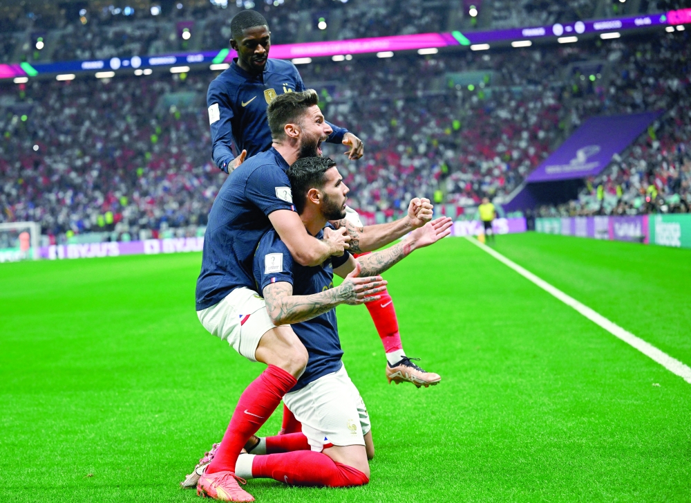 Soccer Football - FIFA World Cup Qatar 2022 - Semi Final - France v Morocco - Al Bayt Stadium, Al Khor, Qatar - December 14, 2022 France's Theo Hernandez celebrates scoring their first goal with Olivier Giroud and Ousmane Dembele REUTERS/Dylan Martinez
