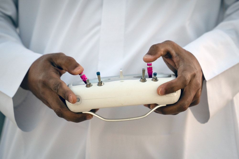 A falconer pilots a drone during a training session for falcons outside of Al Khor, Qatar, on Dec. 3, 2022.   (Erin Schaff/The New York Times)