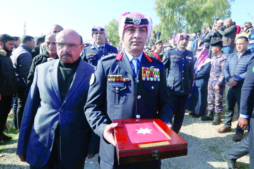 Jordanian military personnel and civilians attend the funeral of a senior police officer in the southern city of Jerash who was killed in riots the previous day. - AFP


