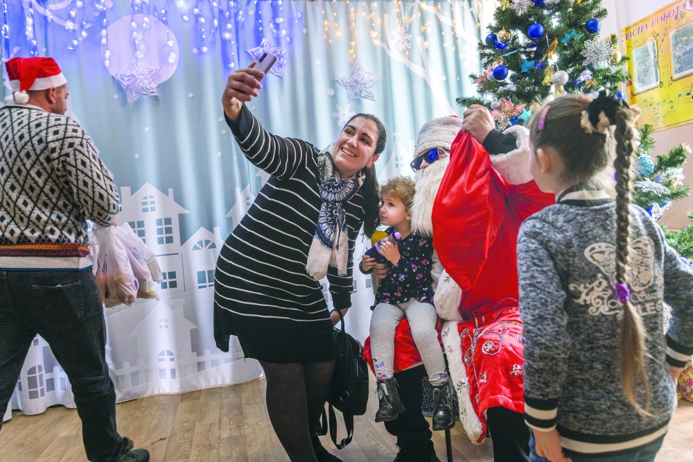 Parents and children take photos with Yevhen Vorobyov, who dressed as Saint Nicholas for a celebration in Mykolaiv, Ukraine.
