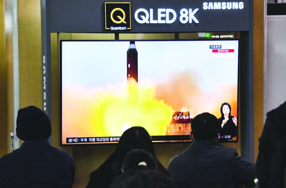 People watch a TV screen showing a news broadcast with file footage of a North Korean missile test at a railway station in Seoul after North Korea fired two short-range ballistic missiles. - AFP
