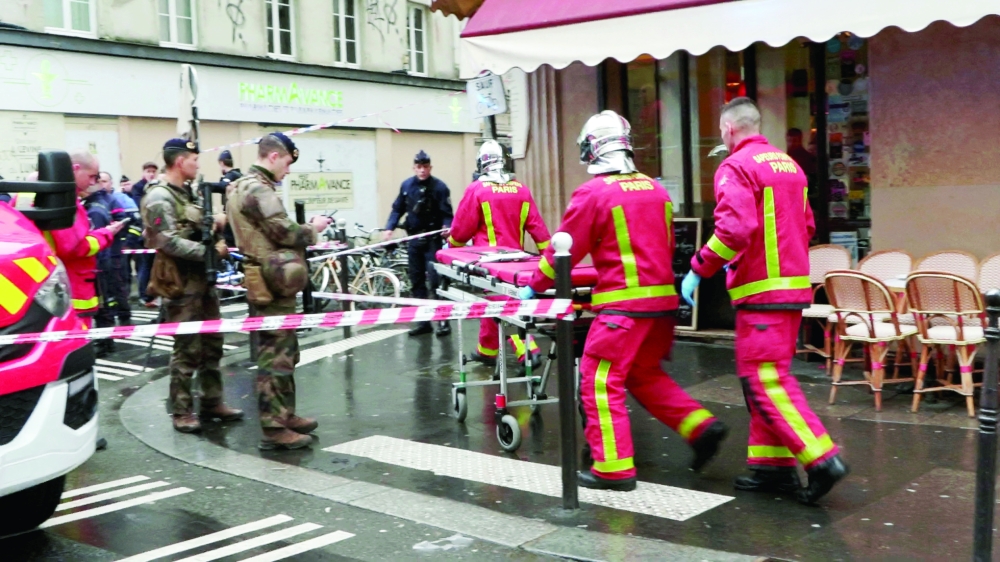 Firefighters push a gurney on a street after gunshots were fired in central Paris. - Reuters
