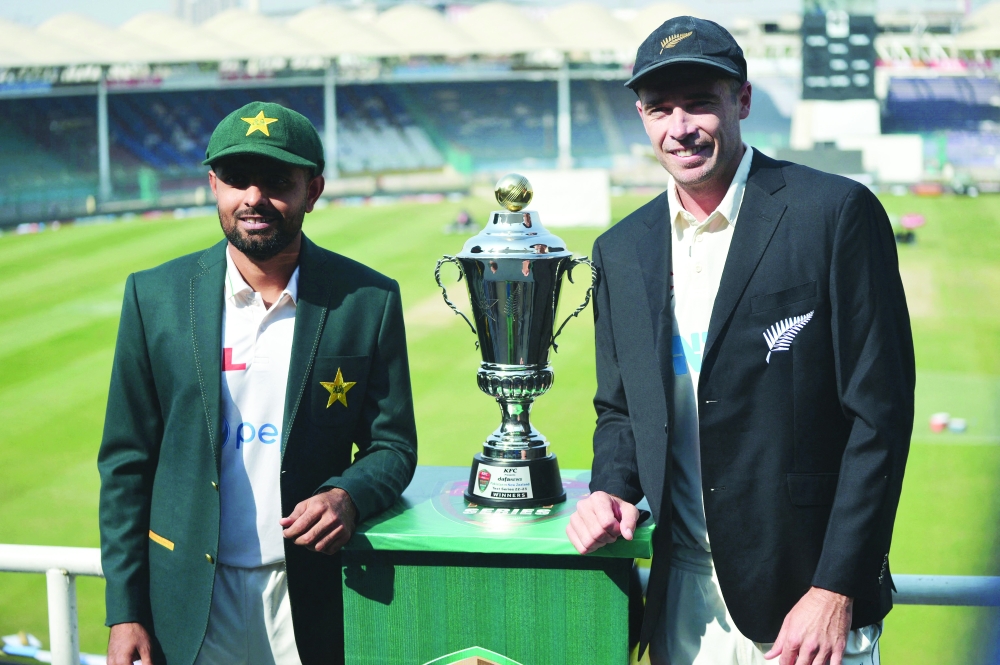 New Zealand's captain Tim Southee (R) and his Pakistan's counterpart Babar Azam unveil the test match trophy on the eve of their first cricket Test match at the National Stadium in Karachi on December 25, 2022.  (Photo by Rizwan TABASSUM / AFP)

