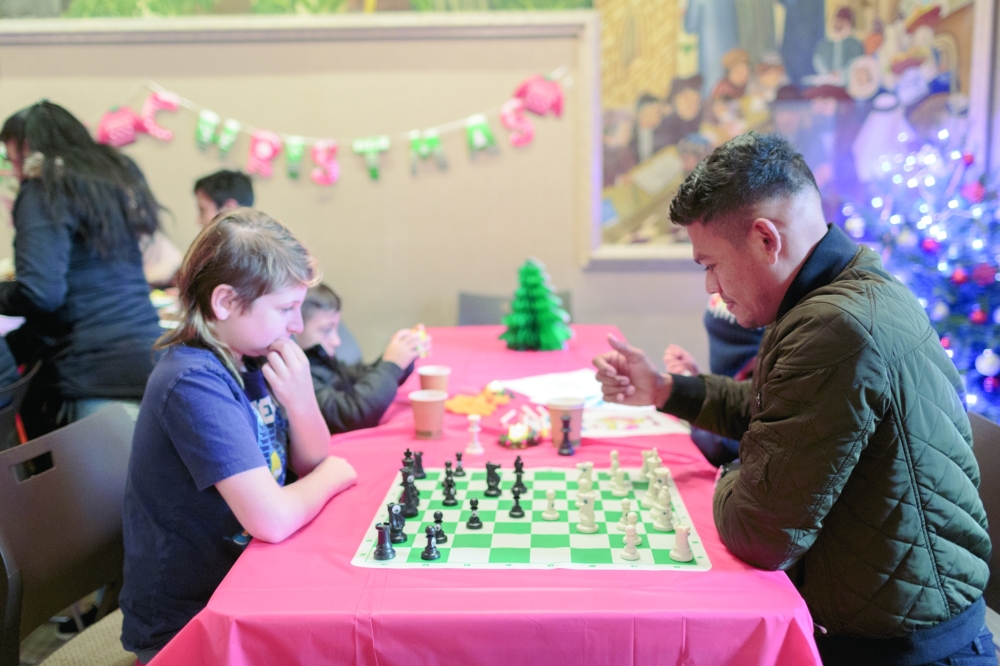 Guests play chess during a Christmas Day party for newly arrived migrants in New York.