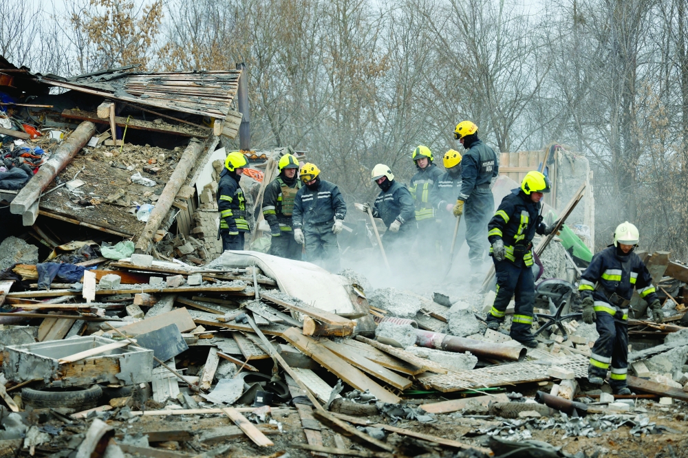 Rescuers work at a site of a residential house damaged during a Russian missile strike in Kyiv. -- Reuters
