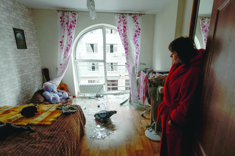 A local resident stands inside a room of her apartment damaged by a Russian drone strike in Kyiv. - Reuters 