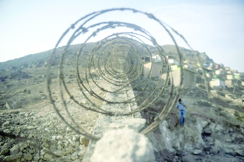 The wall in Peru's capital Lima is 10 kilometers long and up to two meters high in some places, topped with barbed wire. -- AFP