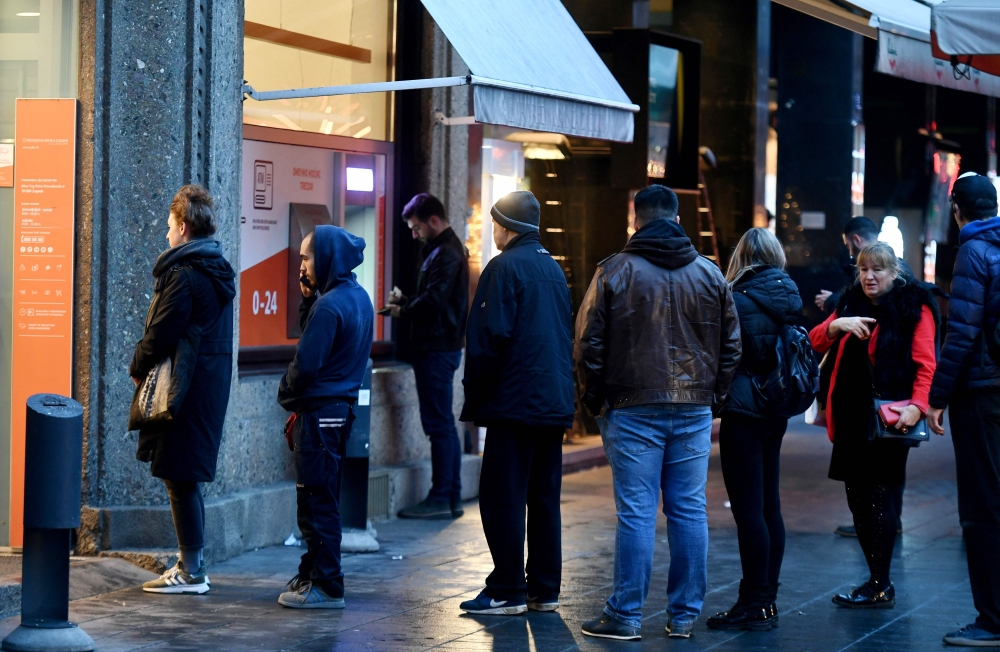 Clients wait in line to withdraw cash at a bank in the center of Zagreb on December 30, 2022, as EURO becomes Croatia's official currency on January 1, 2023.