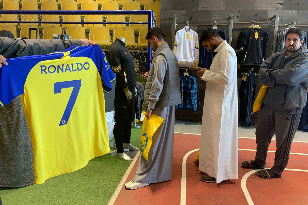 A fan holds t-shirt bearing the name Ronaldo and number 7, at the Saudi Al Nassr FC shop in the Saudi capital Ryadh, on December 31, 2022.