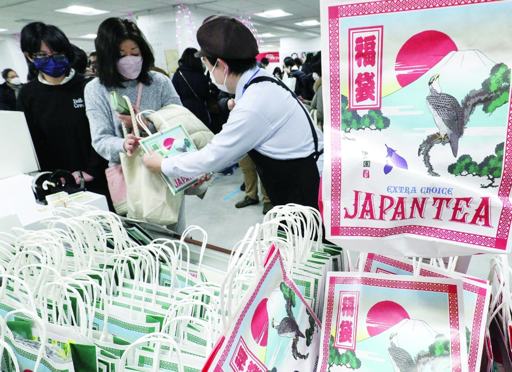 Customers buy lucky bags containing items valued more than the cost, traditionally sold for the New Year's Day sales, at a department store in the Ikebukuro district of Tokyo on Sunday.  — AFP
