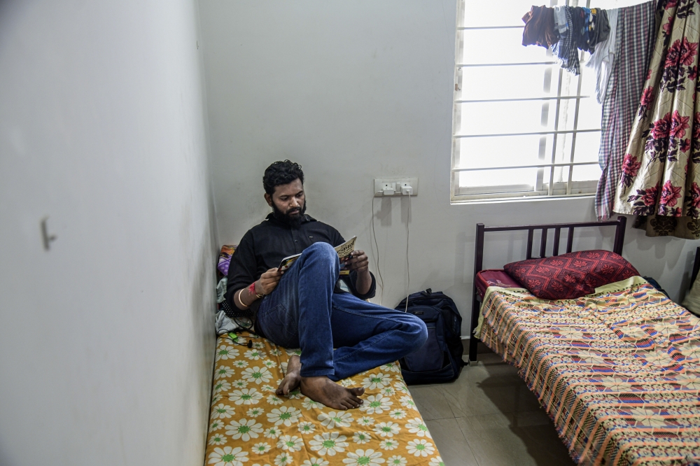 Shivam Neralwar, a delivery driver for Swiggy, studies for a master’s degree at a hostel where he lives in Hyderabad, India, Dec. 2, 2022. (Atul Loke/The New York Times)