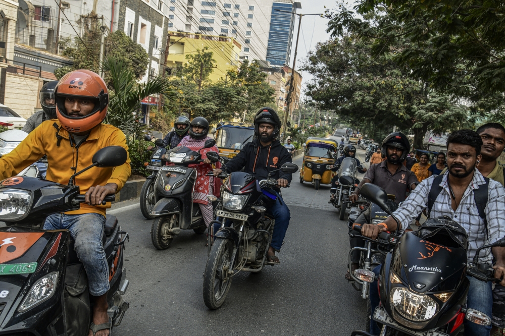 Shivam Neralwar, center, a delivery driver for Swiggy, rides to a delivery in Hyderabad, India, Dec. 2, 2022. (Atul Loke/The New York Times)