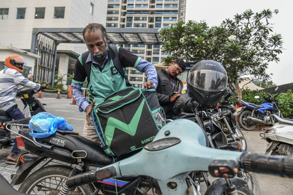 Venkat Rao, a delivery driver for the Dunzo app, packs his next delivery in Hyderabad, India, Dec. 2, 2022. (Atul Loke/The New York Times)