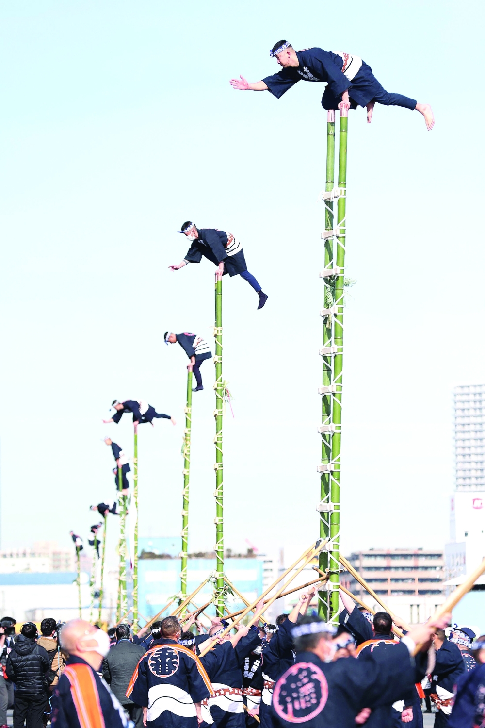 Members of the Edo Firemen Preservation Association perform traditional firefighting techniques as they balance on the top of bamboo ladders, during the annual New Year's fire brigades exercise in Tokyo on Friday. -- AFP