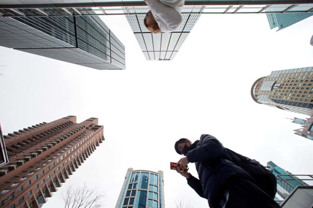 A man checks phone at Lujiazui financial district in Pudong, Shanghai, China. — Reuters