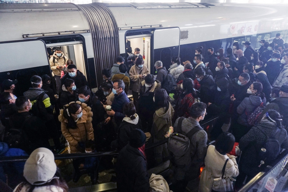 This photo taken on January 7, 2023 shows passengers board their train at Hangzhou East railway station