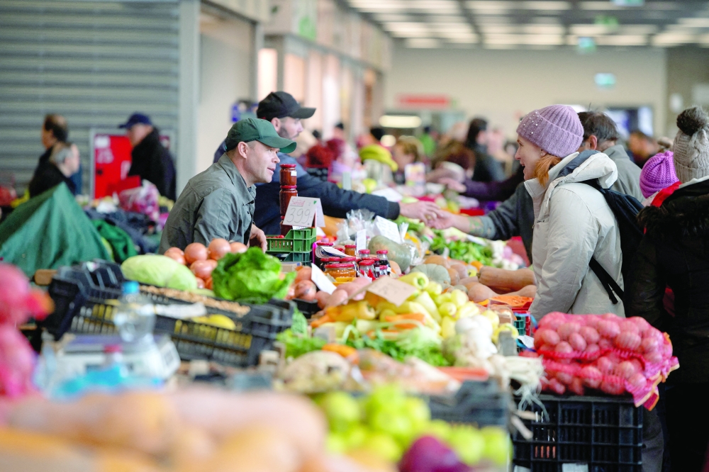 People buy food at a market in Budapest, Hungary. -- Reuters