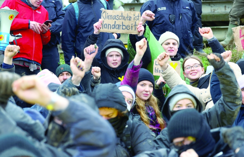 Fridays For Future activist Luisa Neubauer holds a sign reading 'Climate protection is manual work', as activists block a road during a sit-in protest against the expansion of the Garzweiler open-cast lignite mine of Germany's utility RWE, in Luetzerath. -- Reuters