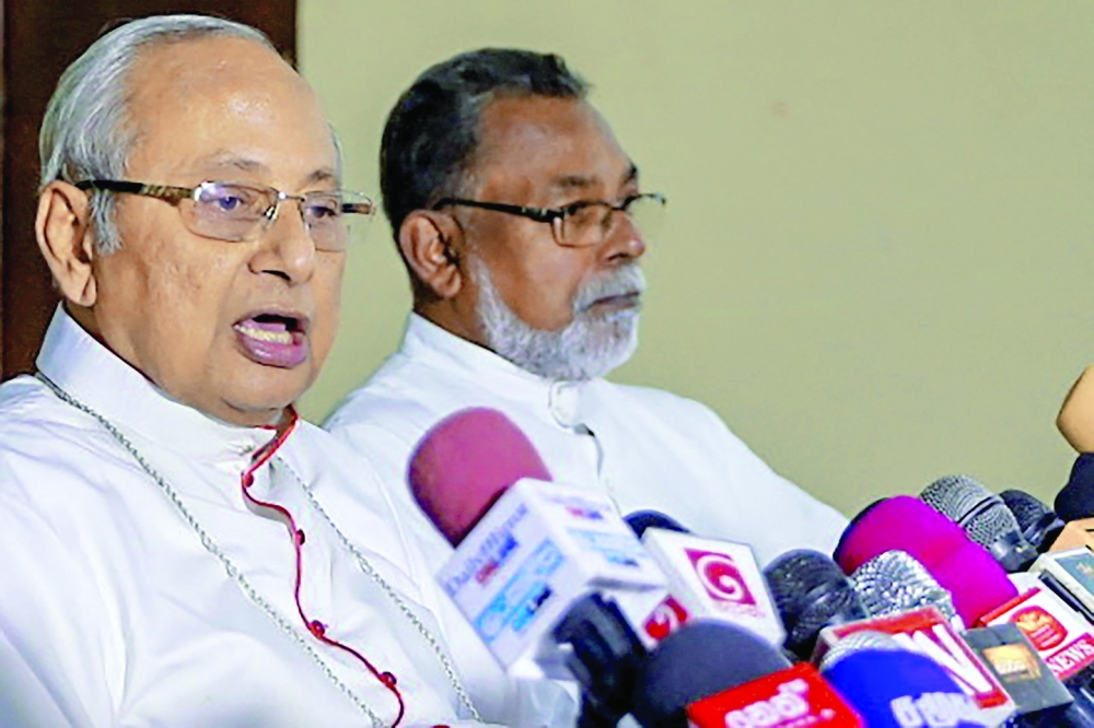 Catholic Archbishop Malcolm Ranjith speaks (L) during a press conference in Colombo. - AFP 
