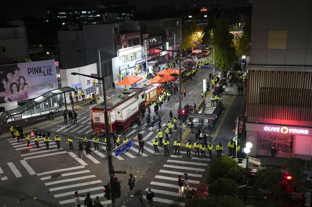 Emergency responders at the scene of a crowd surge in which at least 146 people were killed and another 150 injured after they were crushed in a large Halloween crowd in Seoul, on Oct. 29, 2022. (Chang W. Lee/The New York Times)