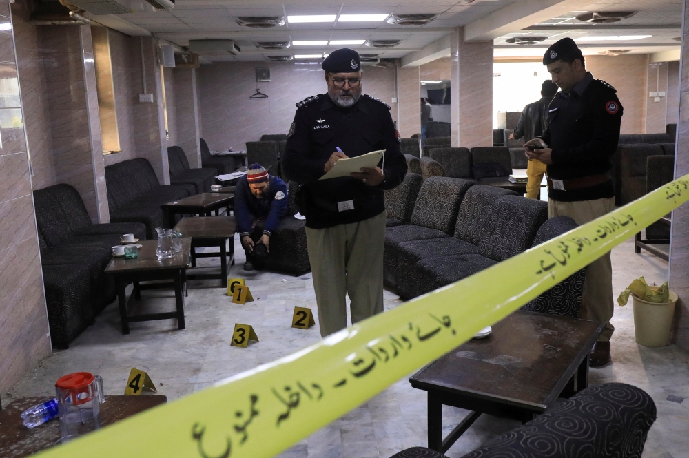 Police officers survey the crime scene after, according to police, a gunman killed Abdul Latif Afridi, lawyer and former president of Pakistan’s Supreme Court Bar Association