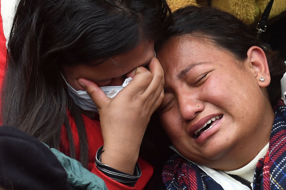 Family members and relatives of victims who died in a Yeti Airlines plane crash, weep outside a hospital in Pokhara on January 16, 2023