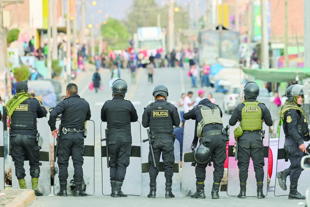 Members of the police stand guard on the street in Humay, Peru after detaining a convoy of members of the Chancas ethnic group on their way to Lima to participate in a major demonstration against Peruvian President Dina Boluarte. - AFP


