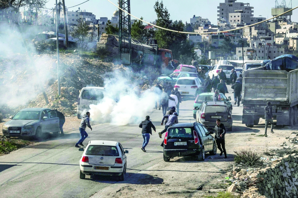 Tear gas is fired by Israeli forces to disperse people and journalists gathering at the scene near the body of Palestinian Hamdi Abu Dayyeh in the village of Halhul north of the city of Hebron in the occupied West Bank. - AFP