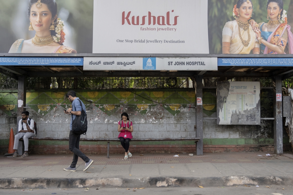 People at a bus stop in Bengaluru, India, Jan. 13, 2023. (Saumya Khandelwal/The New York Times)