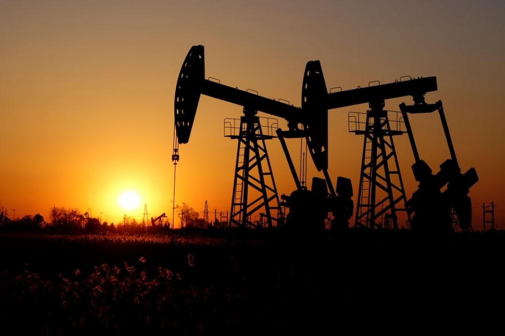 Pumpjacks are seen against the setting sun at the Daqing oil field in Heilongjiang province, China. — Reuters