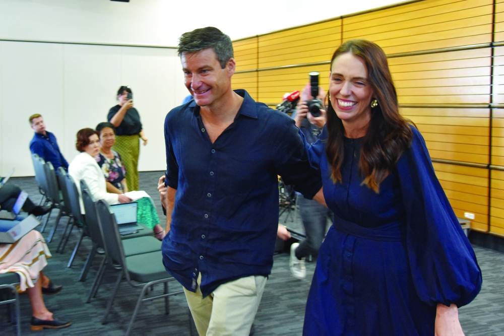 New Zealand Prime Minister Jacinda Ardern leaves with longtime partner Clarke Gayford following the announcement of her resignation at the War Memorial Hall in Napier on Thursday. -- Reuters