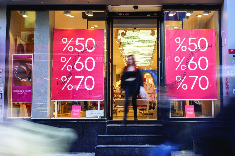 A customer leaves a shop advertising sales in Istanbul on Thursday. — Reuters