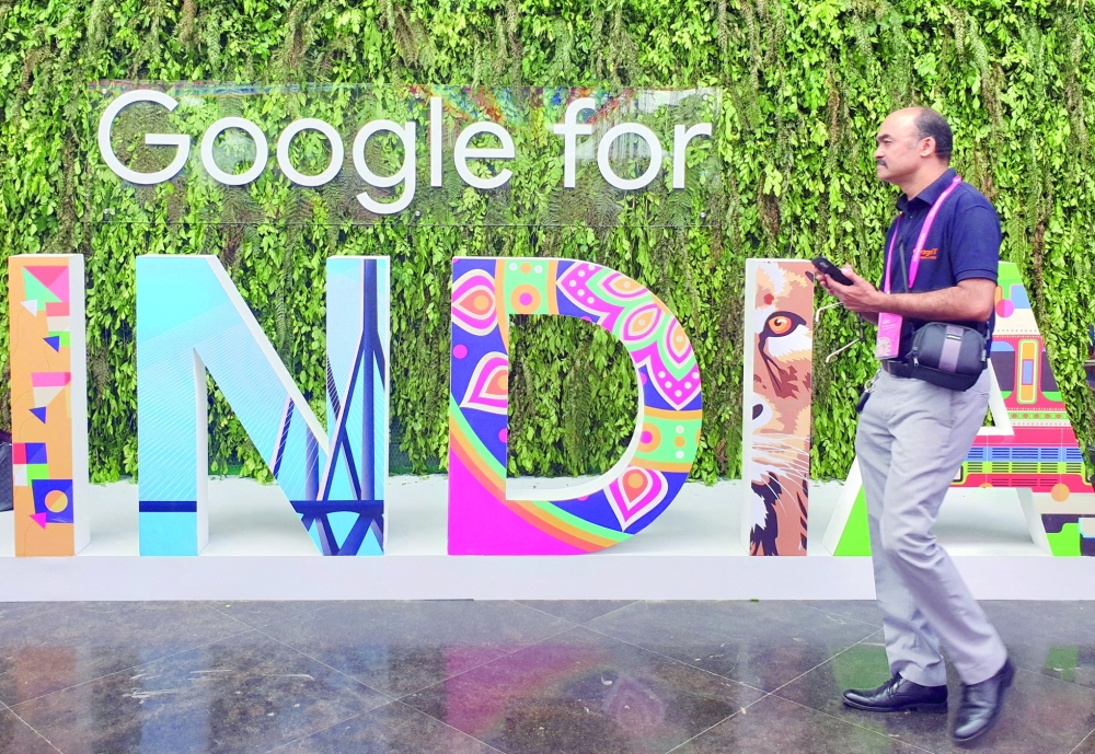 A man walks past the sign of 'Google for India', the company's annual technology event in New Delhi. - Reuters File  
