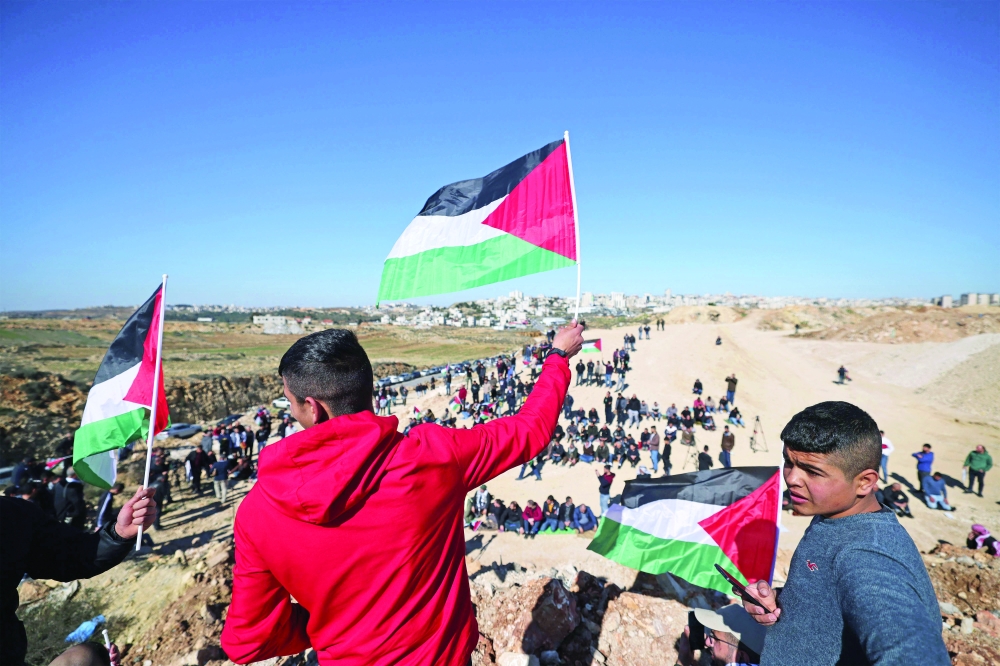 Palestinians take part in a demonstration in Qalandia village near Ramallah in the occupied West Bank, to protest Israeli plans to expand the Atarot settlement industrial zone and to construct a new settlement in the area. - AFP