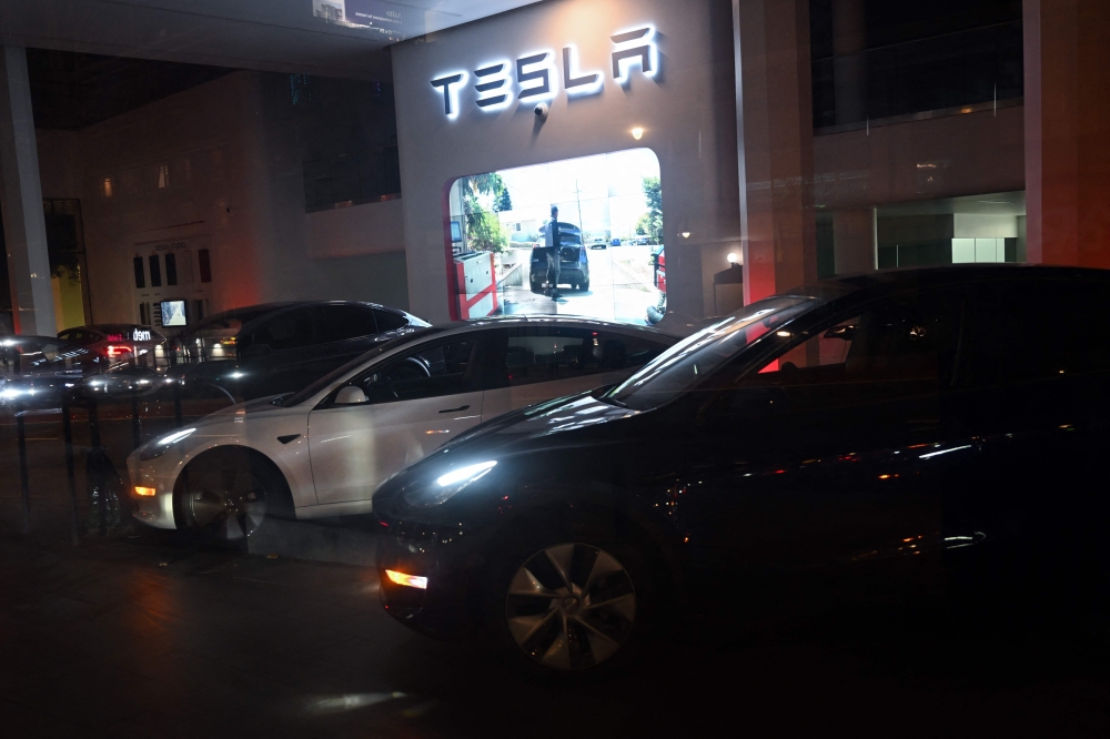 Lights glow from Tesla Inc. electric vehicles displayed in the dark at night at a Tesla showroom location on Van Ness Avenue 