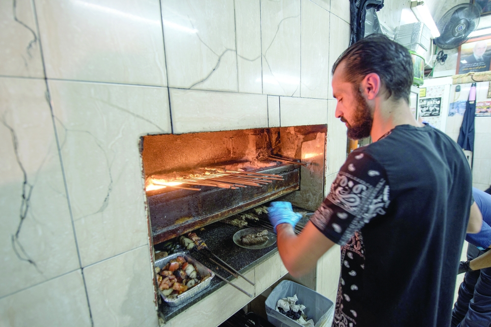 The coal-fired grill at the Kabab al Shaab restaurant turns out skewers of meat all day, in the Old City of Jerusalem, Oct. 12, 2022. (Tzachi Ostrovsky/The New York Times)