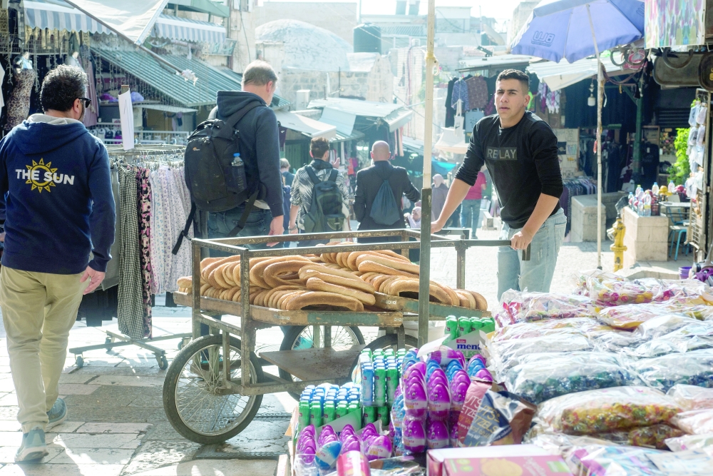 A vendor sells kaak-al-quds (oval ring-shaped sesame-studded breads) from Al Razim bakery, in the Old City of Jerusalem, Oct. 12, 2022. (Tzachi Ostrovsky/The New York Times)