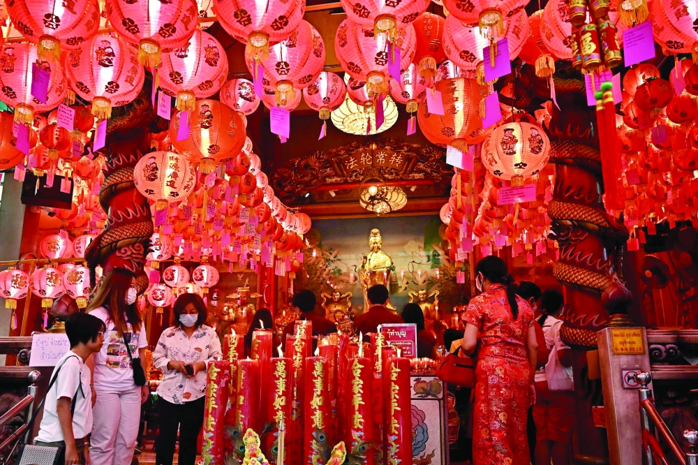 People pray at a shrine in the Chinatown area of Bangkok on Sunday, on the first day of the Lunar New Year of the Rabbit. - AFP