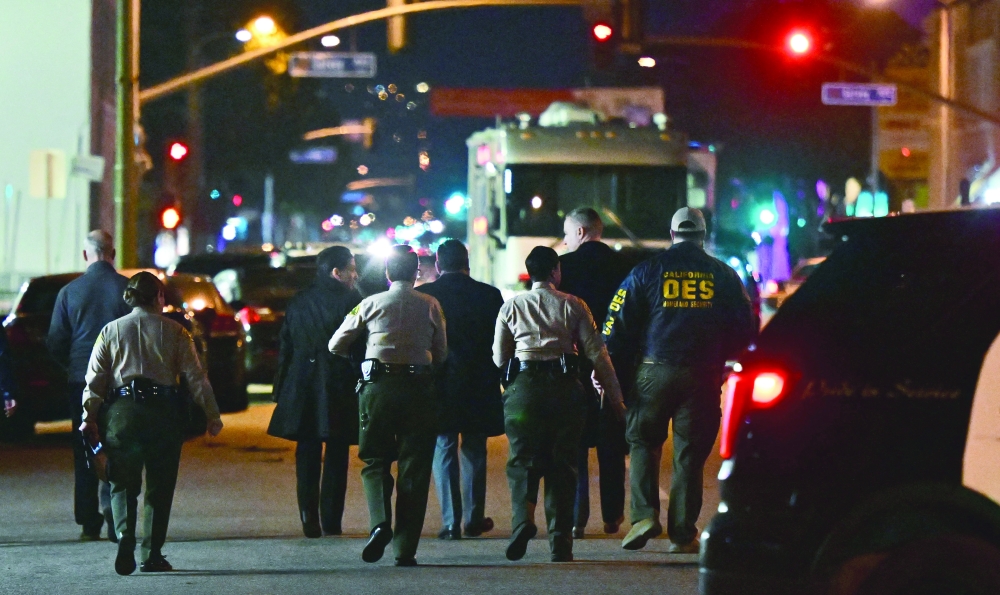 Investigators from the Los Angeles County Sheriff's Department Homicide bureau walk away after briefing the media in Monterey Park, California  on Sunday. -- AFP