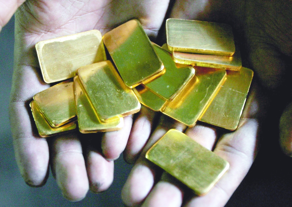 A worker shows gold biscuits at a precious metals refinery in Mumbai, India. - Reuters file photo

